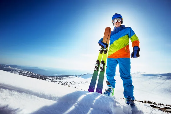 Gelukkig skiër in kleurrijke kleding met skipas — Stockfoto