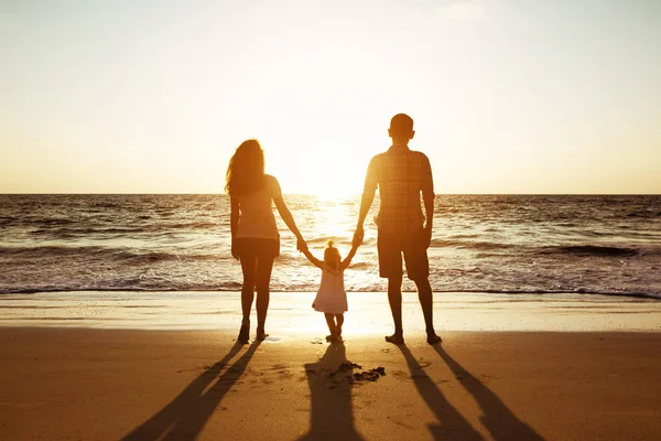 Família de pai mãe e filha pôr do sol silhuetas do mar — Fotografia de Stock