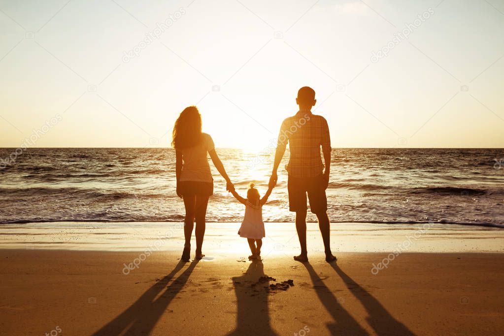 Family of father mother and daughter sunset sea silhouettes