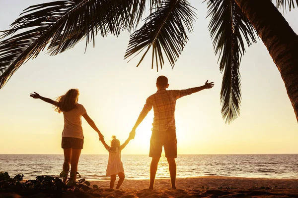 Happy family of mother father and daughter under palm — Stock Photo, Image