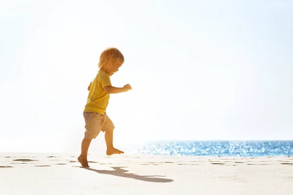 Bebé feliz caminando en la playa solitaria —  Fotos de Stock