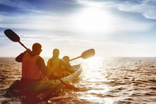 Family of father mother and son kayaking at sea sunset — Stock Photo, Image