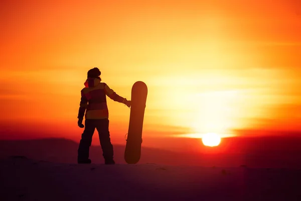 Sylwetka snowboardzista kobieta na tle zachodu słońca — Zdjęcie stockowe