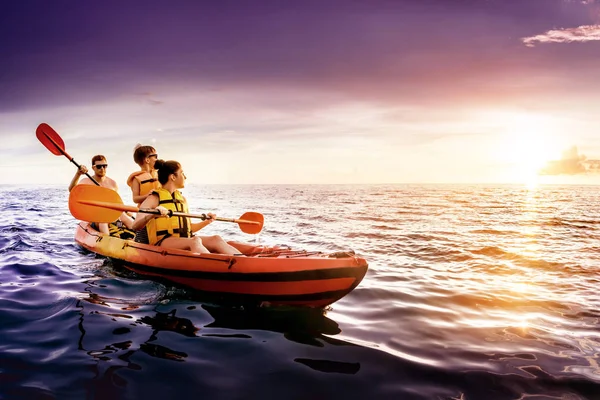 Familia feliz nada en kayak al atardecer del mar — Foto de Stock