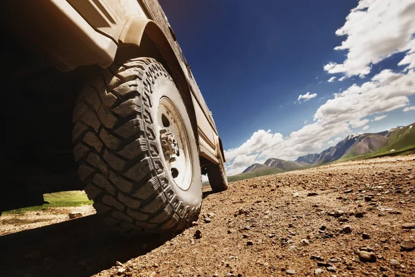 Grande roda de carro offroad na estrada do país — Fotografia de Stock