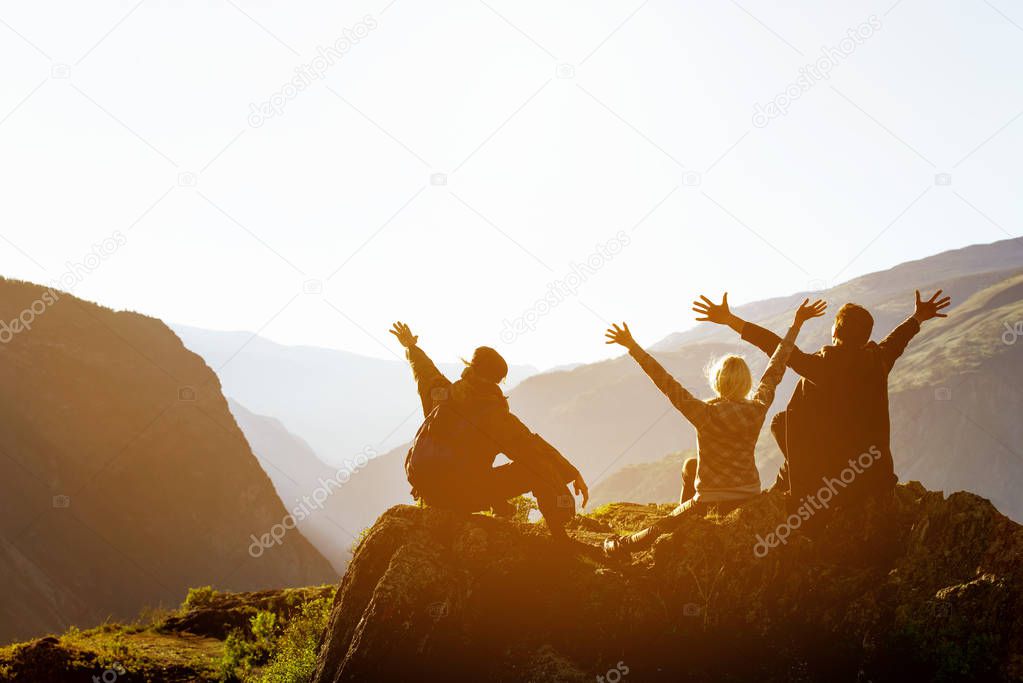 Happy friends at sunset in mountains range