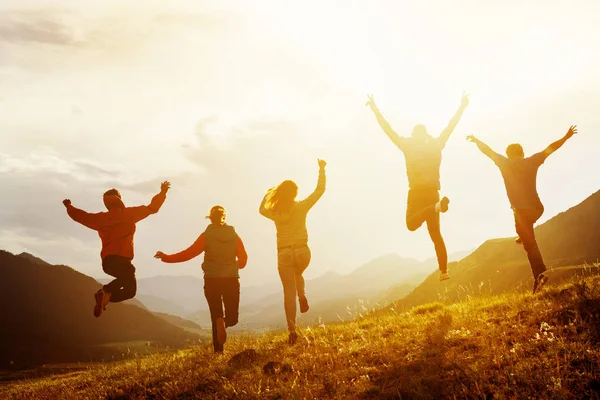Grupp av glada vänner springa och hoppa — Stockfoto