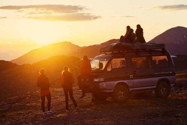 Amis au sommet de la montagne regardant au coucher du soleil — Photo