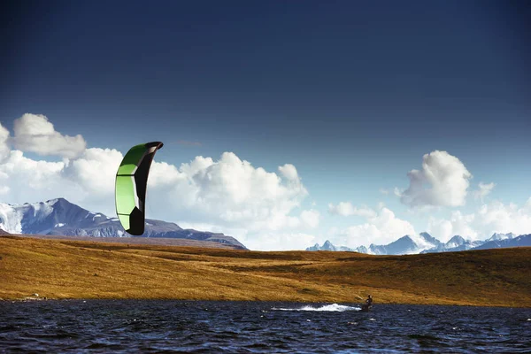 Kite surfing at mountain lake — Stock Photo, Image