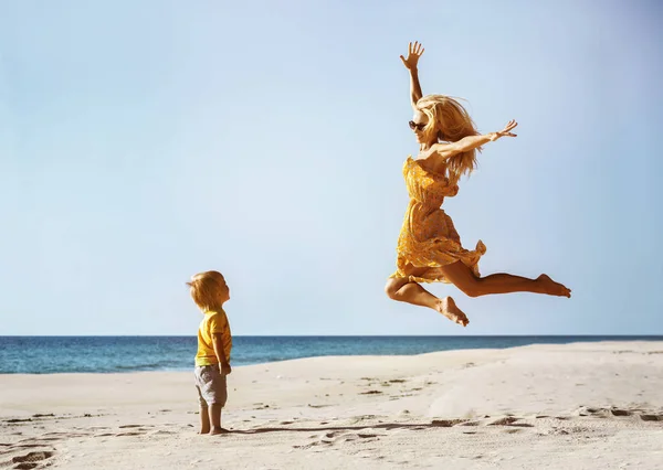 재미 해변에서 점프 하는 행복 한 어머니 — 스톡 사진