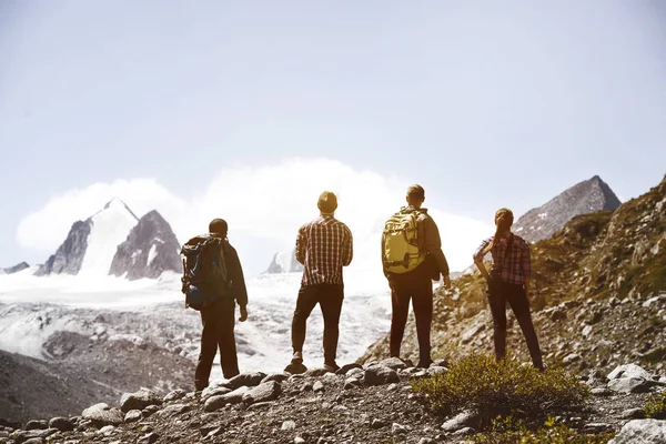 Groupe quatre amis trekking montagnes — Photo