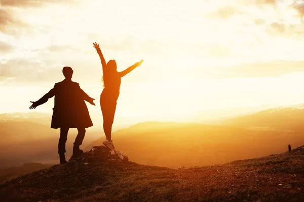 Gelukkige paar opgeheven armen zonsondergang berg — Stockfoto