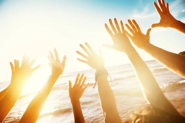 Vänner resa koncept med händerna och sunset sea — Stockfoto