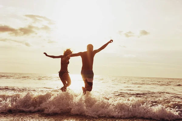 愉快的夫妇日落海滩奔跑 — 图库照片