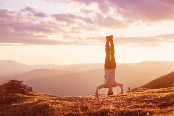 L'uomo si trova a testa in giù al tramonto di montagna — Foto Stock