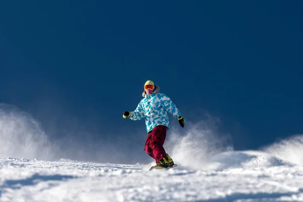 Snowboardista na sjezdovce proti modré obloze — Stock fotografie