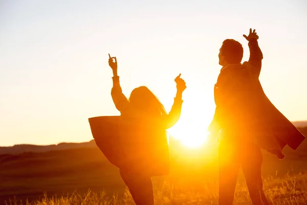 Pareja feliz baila contra el atardecer — Foto de Stock