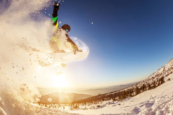 Snowboardista skáče proti západu slunce — Stock fotografie