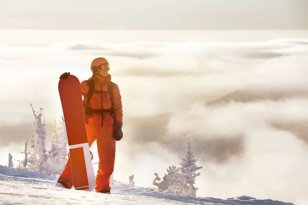 Концепція сноубордингу з людиною та сноубордом на вершині гори — стокове фото