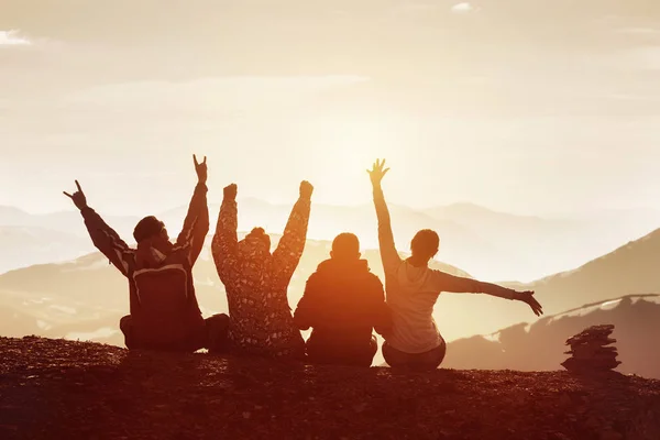 Vier glückliche Freunde, die Spaß vor den Bergen des Sonnenuntergangs haben — Stockfoto