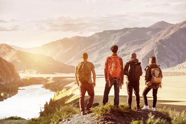 Ηλιοβασίλεμα στα βουνά τέσσερις φίλοι ταξιδεύουν έννοια — Φωτογραφία Αρχείου