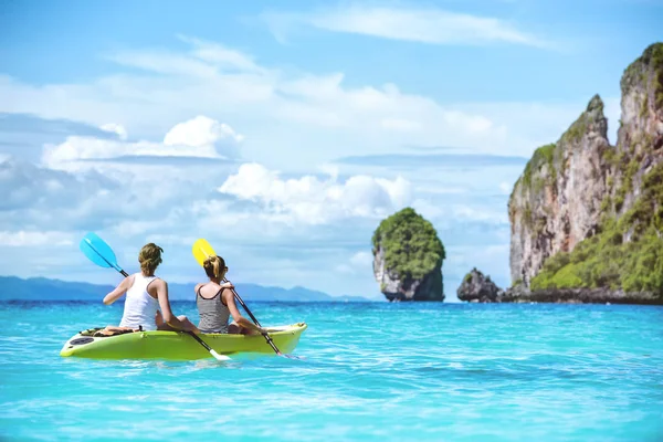 Twee meisjes kajakken kanoeing prachtige zee baai — Stockfoto