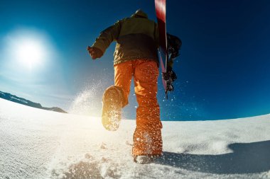 Snowboardcu kayak yapmaya gidiyor.