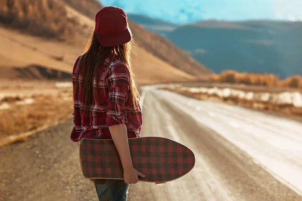 Menina bonita com longboard fica na estrada reta — Fotografia de Stock