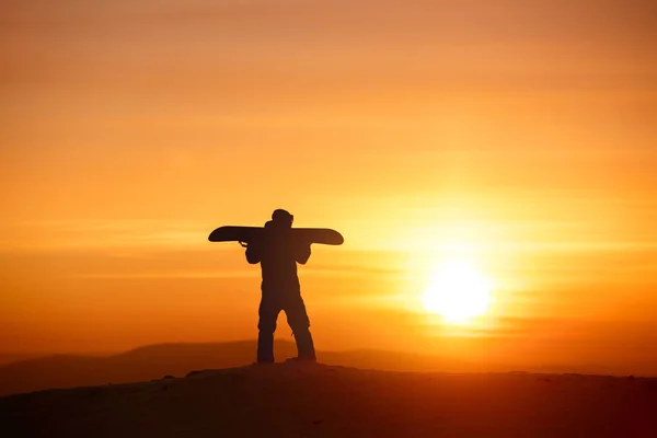 Snowboarder Silhouette steht gegen das Sonnenuntergangslicht — Stockfoto