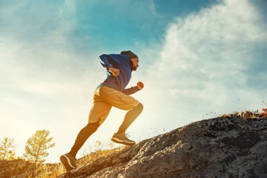 Skyrunner, büyük kayalıklardaki genç atletle hava koşusu kavramı