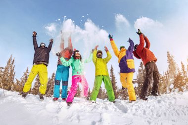 Mutlu arkadaşlar kayakçılar ve snowboardcular eğleniyor.