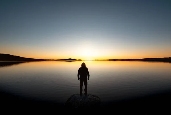 Silhueta homem solitário no lago pôr do sol — Fotografia de Stock