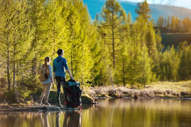 İki yürüyüşçü dağ gölünde dinleniyor.