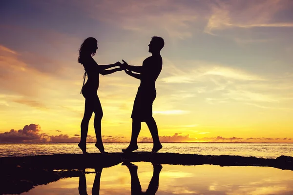Slim sportowe piękne pary sylwetki na plaży zachód słońca — Zdjęcie stockowe
