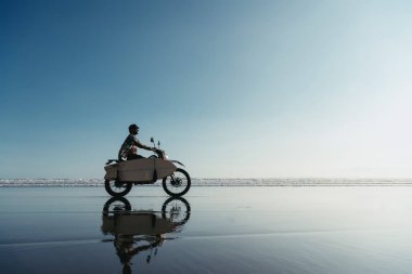 Sahilde motosikletle sörf yapan sörfçü.