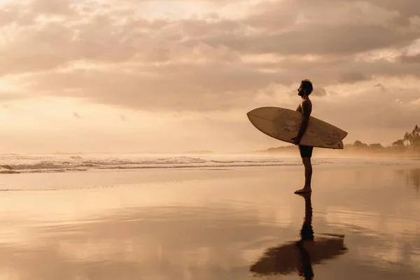 Surfare står på solnedgången havet stranden — Stockfoto