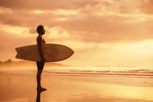 Atraktivní sportovní skutečný surfař při západu slunce oceánské pláže — Stock fotografie