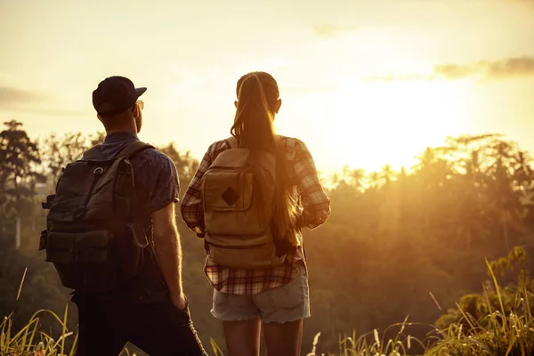 Paar reizigers met rugzakken kijkt naar zonsopgang — Stockfoto