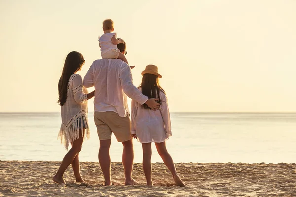 Famiglia di quattro persone con piccole figlie al tramonto spiaggia sul mare — Foto Stock