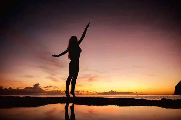 Gün batımında kollarını kaldırmış mayolu mutlu bir kadın. — Stok fotoğraf