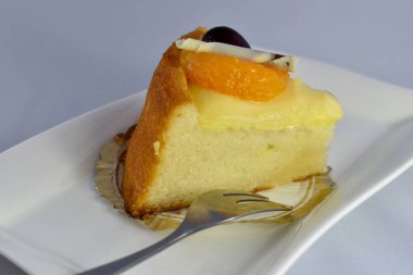 Taze meyve tepesi ile lezzetli vanilyalı pasta dilimi 