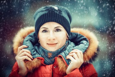 güzel kız şapka ve puf bir kar yağışı altında