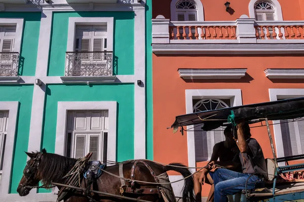Carruagem puxando cavalo na frente da fachada colonial colorida — Fotografia de Stock