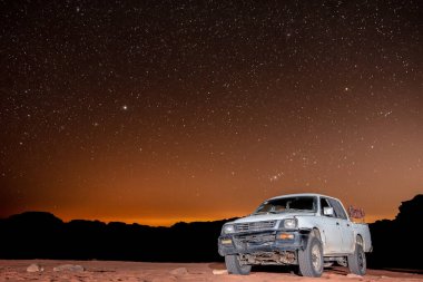 Ürdün 'deki Wadi Rum Çölü' nde kamyonun üstündeki yıldızlarla temiz bir gece.