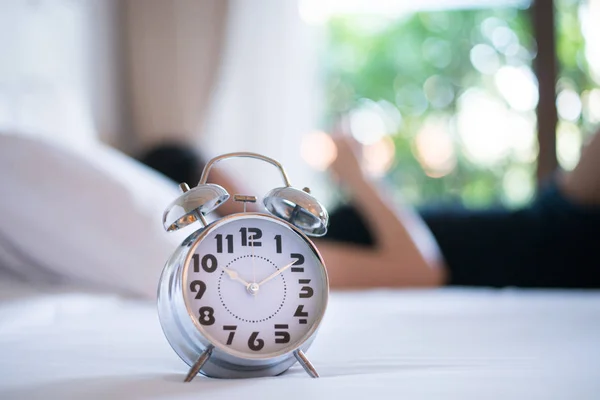 Relógio de alarme clássico na cama de manhã . — Fotografia de Stock