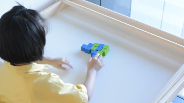 A girl playing wooden box on table. — Stock Video