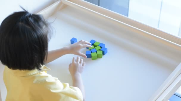 A girl playing wooden box on table. — Stock Video