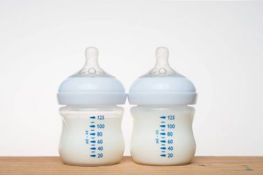 Beyaz arka planda bir şişe süt.