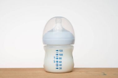 Beyaz arka planda bir şişe süt.