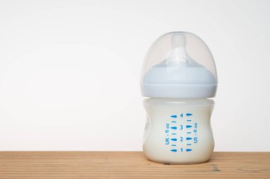 Beyaz arka planda bir şişe süt.